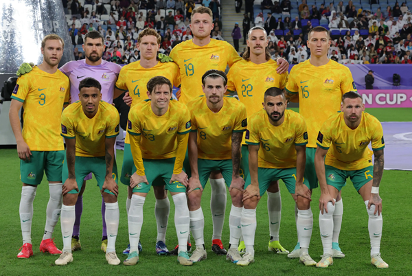 USA national soccer team lineup posing on field in yellow jerseys before a packed stadium crowd.