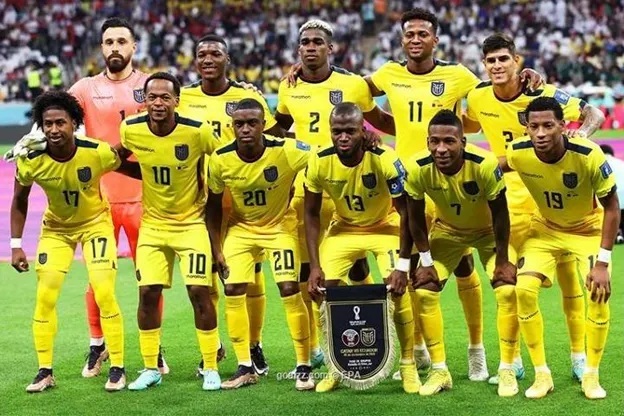 Equador national soccer team posing in yellow uniforms on the field before a match.