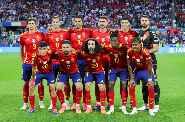 Spain national soccer team poses for a group photo on the field before a match.