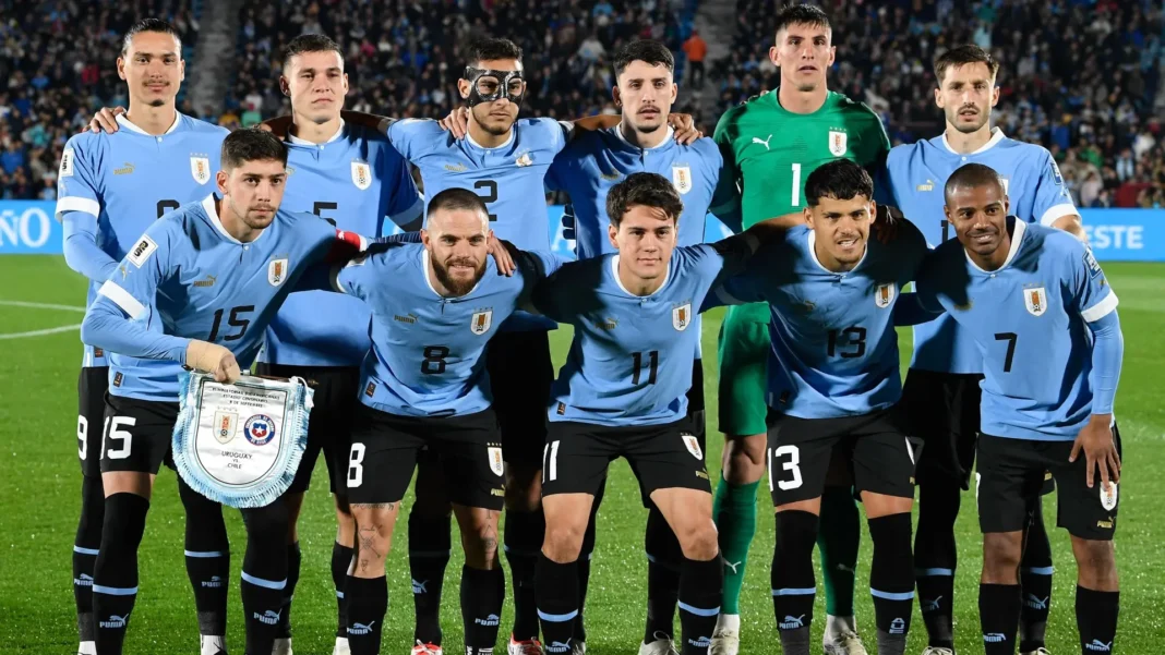 Uruguay players pose for a team photo on the soccer field before kickoff.