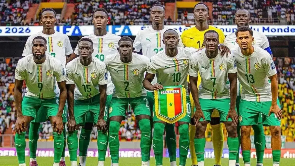 Senegal national football team players posing together on field, wearing green kits with numbers and crest.