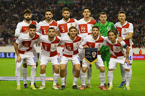 Croatia national football team posing in white kits with captain holding a trophy during a match.