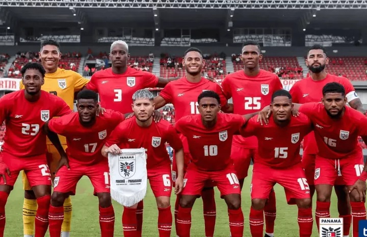 Panama national soccer team posing in red uniforms inside a stadium before a match.